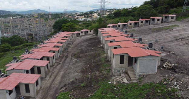 Two rows of small cinder block homes with red roofs in Mexico